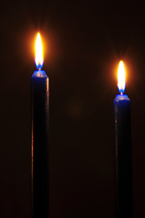 Flaming candles in darknessの写真素材
