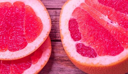 A view from above of a fresh citrus fruit called grapefruit. Half fruit and two juicy slices side by side.の写真素材