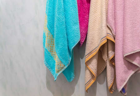 In the bathroom on hooks hang terry towels of different colorsの写真素材