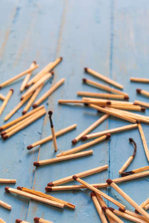 One charred match stands, and all the others are on a wooden tableの写真素材