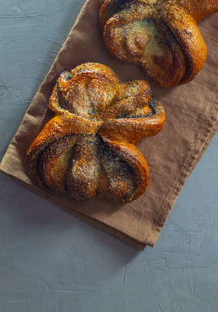 The buns with poppy seeds and sugar lie on the kitchen towel