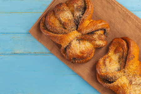 The horizontal image from the top view shows the food. These are buns with sugar and poppy seeds in...