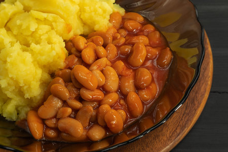 Close-up of white beans in tomato gravy and mashed potatoes