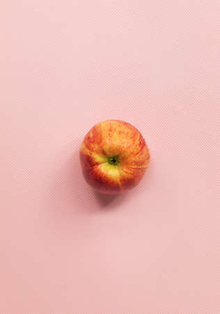 On a pink background in the upper corner there are three ripe applesの写真素材