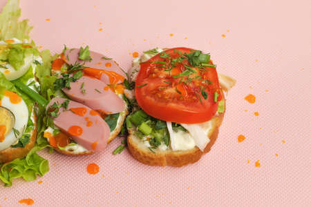 The pink background shows a ready-made and fast food. These are sandwiches with meat, vegetables, herbs and garlic sauce. Sandwiches are homemade, collected at home.の写真素材