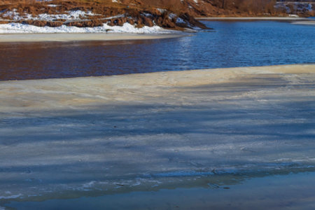 On the river in a small town in Russia at the end of March, snow and ice floes melt