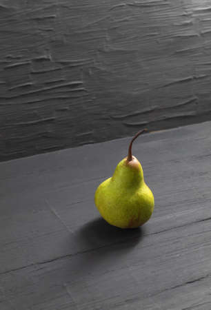 The vertical photo shows an image of a ripe fruit. This is a juicy pear. Whole pear, peeled, green in colorの写真素材