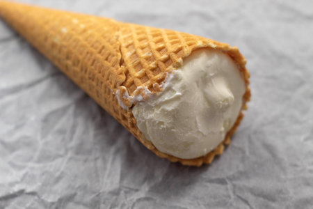 The photo shows an image of a sweet treat. It's ice cream. Ice cream in a waffle cone. There is only...