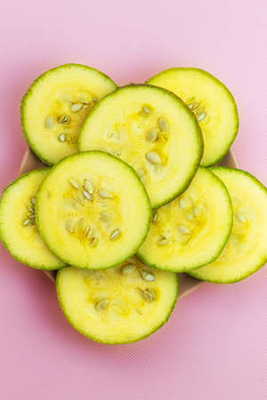On a pink background, the image of fresh zucchini in a plateの写真素材