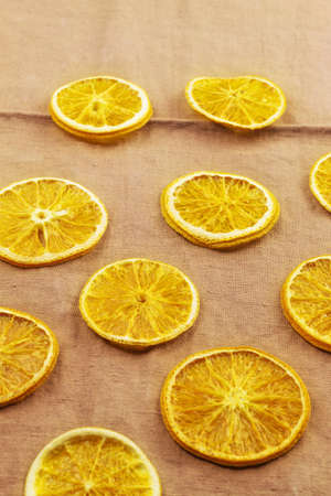 Slices of dried orange lie on a brown kitchen towelの写真素材