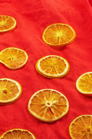 Slices of dried orange lie on a red backgroundの写真素材
