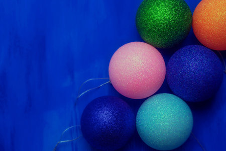 A small amount of Christmas decorations lies on a blue background