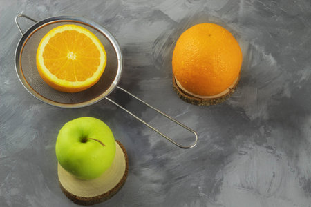 There are fruits on the table. It's an orange and an apple