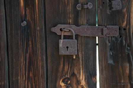 Old, rusty padlock on the wooden hangar doors, close-up, Ukraine