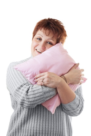 Happy woman hugs pink pillow isolated on whiteの写真素材
