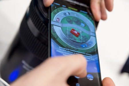 MOSCOW, RUSSIA - MARCH 28, 2018: Men's hands hold the flagship model of the SAMSUNG GALAXY S9 plus phone near a stand in the SAMSUNG brand store to show  capabilities to super slow motion videoのeditorial素材