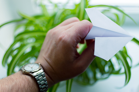 Watch and paper airplane in hand. Action to launch aircraft in support of the Telegram application. A popular messenger Telegram is banned in Russia.の写真素材