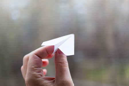 A paper airplane in his hand. Action to launch aircraft in support of the Telegram application. A popular messenger Telegram is banned in Russiaの写真素材