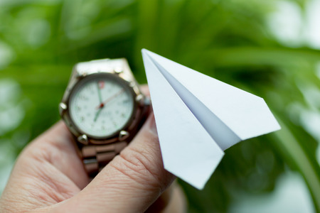 Watch and paper airplane in hand. Action to launch aircraft in support of the Telegram application. A popular messenger Telegram is banned in Russia.の写真素材