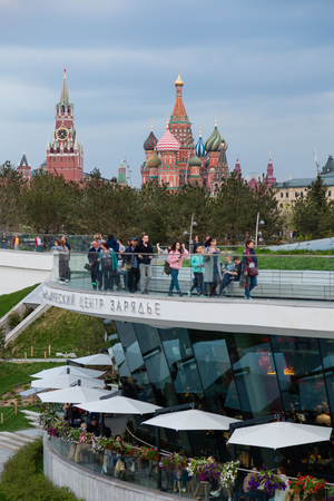 MOSCOW, RUSSIA - APRIL 30, 2018: View of the Moscow Kremlin, Spassky Tower and St. Basil's Cathedral from the observation deck of Zaryadie Park. Strolling people. Evening before sunset.のeditorial素材