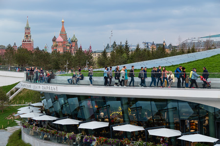 MOSCOW, RUSSIA - APRIL 30, 2018: View of the Moscow Kremlin, Spassky Tower and St. Basil's Cathedral from the observation deck of Zaryadie Park. Strolling people. Evening before sunset.のeditorial素材