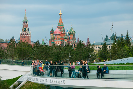 MOSCOW, RUSSIA - APRIL 30, 2018: View of the Moscow Kremlin, Spassky Tower and St. Basil's Cathedral from the observation deck of Zaryadie Park. Strolling people. Evening before sunset.のeditorial素材