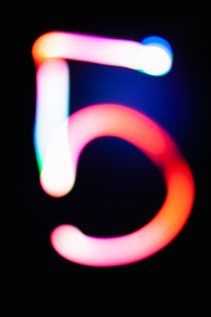 Digit 5. Five. Glowing numbers on dark background. Abstract light painting at night. Creative artistic colorful bokeh. New Year. Use it for build you own design for book cover, poster or post card.の写真素材