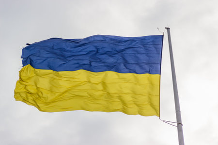 The flag of Ukraine flutters in the wind on a high flagpole in Dnipro city. Shooting at close range....