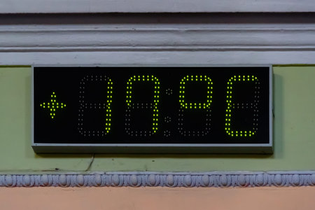 Decorative digital flat LED display panel attached to the wall painted with pink and light green...