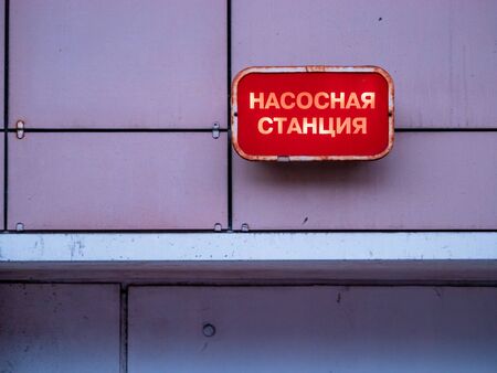 Red industrial plate with light on the wall of the building above the entrance to the basement with the inscription in Russian - Pumping Station. Moscow, Russia.の写真素材