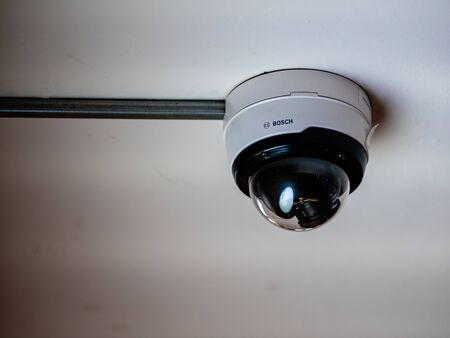 Moscow, Russia - February 8, 2020: Dome surveillance camera in a transparent hemisphere with the inscription and logo of Bosch. CCTV video camera on the ceiling in the subwayのeditorial素材
