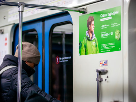 Moscow, Russia - February 8, 2020: A man rides in a subway car next to an Delivery Club...