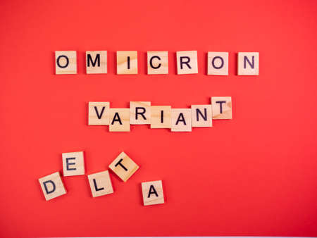 Omicron variant replaces Delta. Emergence of new dangerous strain of coronavirus COVID-19 Omicron. Words omicron variant delta on colored red backgroundの写真素材