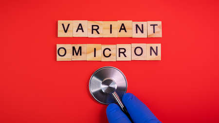 Omicron variant displaces Delta. Emergence of new dangerous strain of coronavirus COVID-19 Omicron. Words omicron variant on colored red backgroundの写真素材