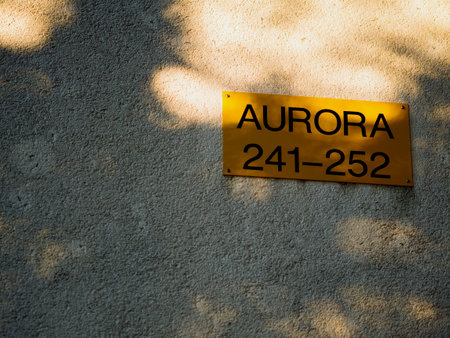 Golden plaque on plastered wall. Inscription Aurora and numbers 241-252. Apartment number in holiday camp. Background for subtitles or intro. Pula, Croatia - December 1, 2024の写真素材
