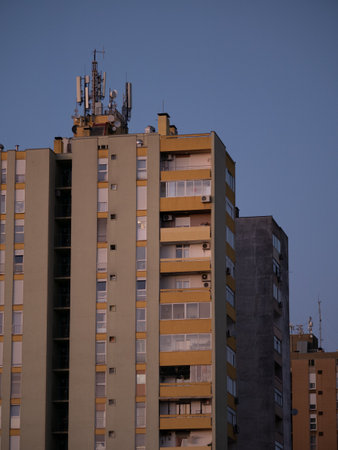 Cellular antennas and transmitters on roof of residential building. Radio transmitting equipment and communication lines on roof. 5G antennas. Evening sunset sky. Pula, Croatia - January 3, 2025の写真素材