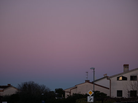 Beautiful color transitions in the sky at dusk after sunset. Natural beauty in nature. Landscape with roofs of city houses. Natural gradient background. Pula, Croatia - January 3, 2025の写真素材