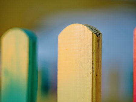 The colorful painted wooden boards on the fence around a playground are illuminated by the rays of the setting sun. Pula, Croatia - January 3, 2025の写真素材