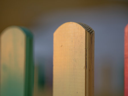 The colorful painted wooden boards on the fence around a playground are illuminated by the rays of the setting sun. Pula, Croatia - January 3, 2025の写真素材
