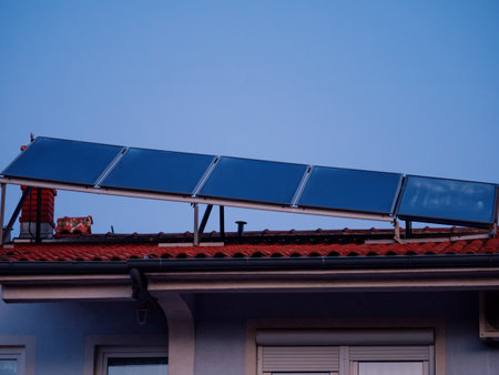 Solar panels installed above the tiled roof. Ventilation pipe with rotating nozzle. Solar energy concept. Pula, Croatia - January 3, 2025の写真素材