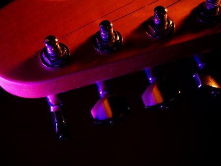 Electric guitar strings close up. Musical instrument details. Concert color contrast lighting. Six-string guitar during performance. Bright colors on dark bsckground. Cinematic light. Copy spaceの写真素材