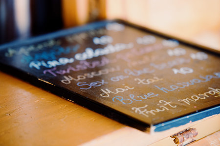 Alcoholic cocktail menu on the bar counter. Wooden board with handwritten chalk inscriptions. Summer...