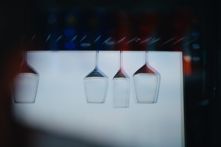 Glasses hanging upside down are reflected in the glass. Double reflections on two glass surfaces of...