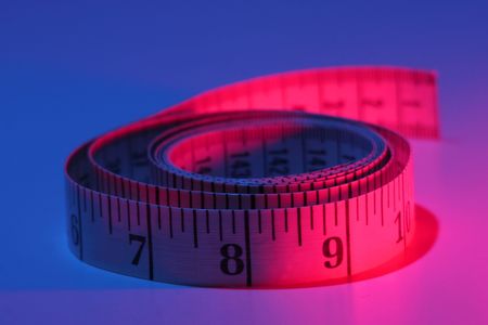 creative lighting on a rolled up measuring tapeの写真素材