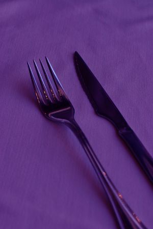 Knife and fork on a purple clothの写真素材
