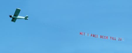 Small airplane towing a spring break banner message through the airの写真素材