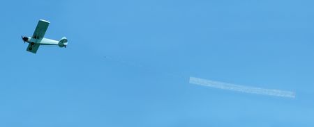 Small airplane towing a blank banner through the air - insert your own messageの写真素材
