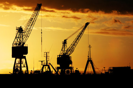 Industrial dock at early dawn - Silhouette of cranes and shipsの写真素材