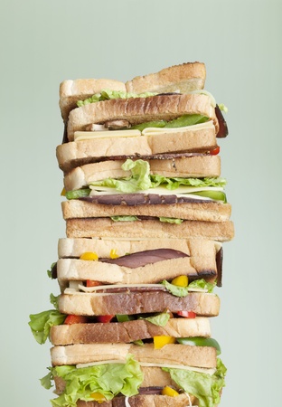 Extra large sandwich with several layers of meat, cheese and vegetablesの写真素材