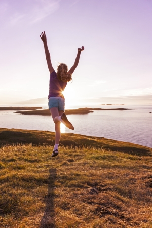 Young girl enjoying life in a beautiful sunsetの写真素材